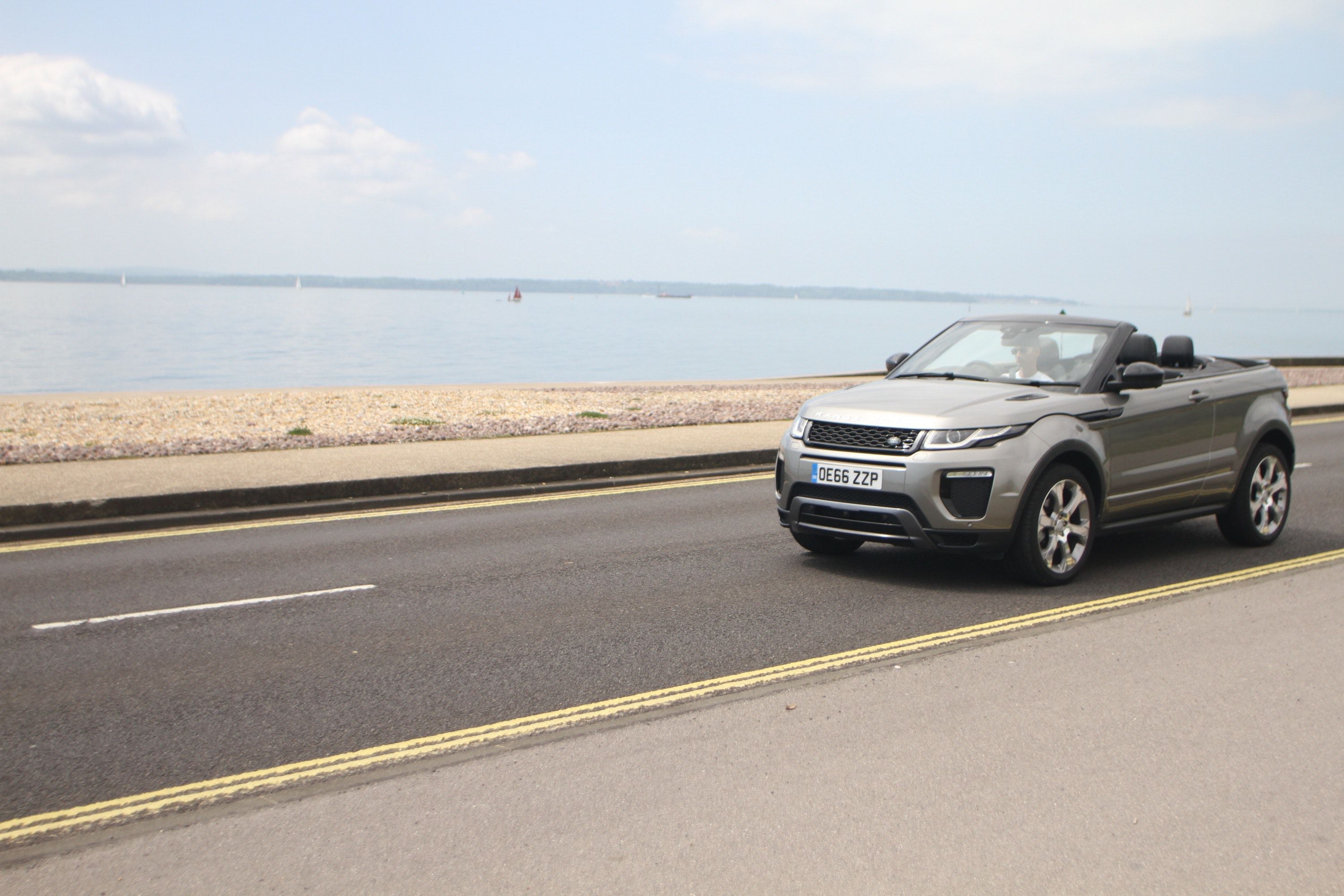Bronze Land Rover Range Rover Evoque convertible car driving by the sea